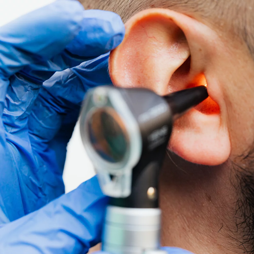 Audiologist looking into patient's ear with an otoscope