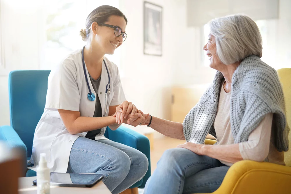 Healthcare professional holding the hand of a senior patient